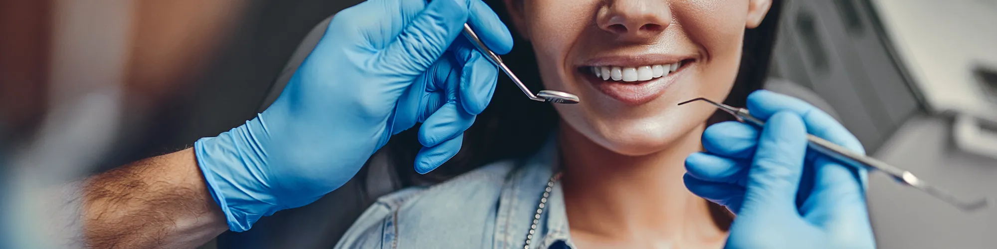Dentist wearing blue gloves preparing to perform an exam. 