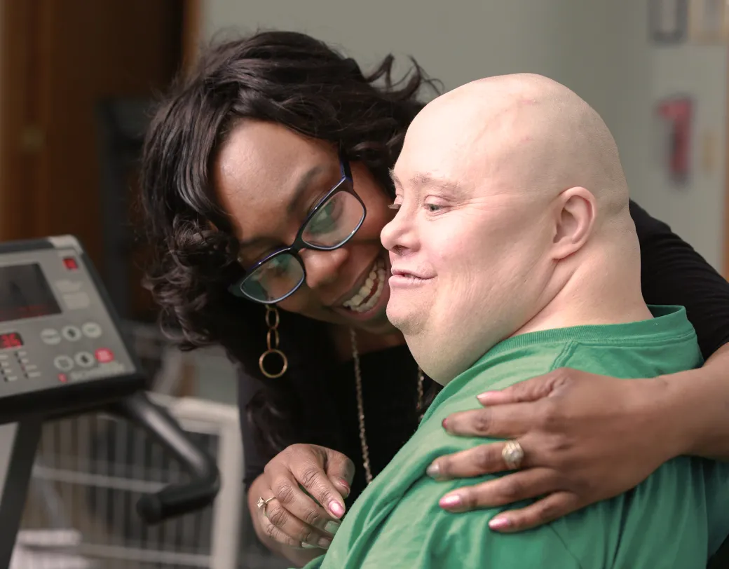 Caregiver with patient at exercise equipment. 