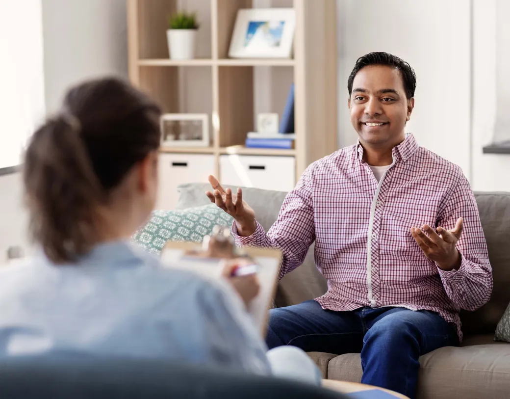 Happy smiling patient and psychologist at psychotherapy session.