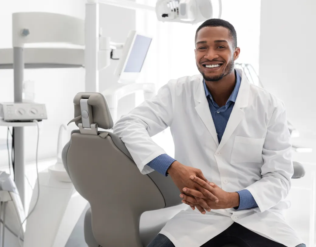 A friendly dentist sitting in his examination room 