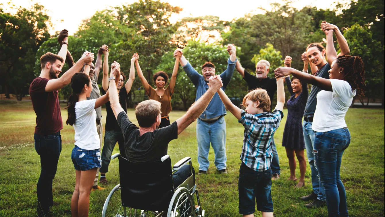 circle of individuals holding raised hands.