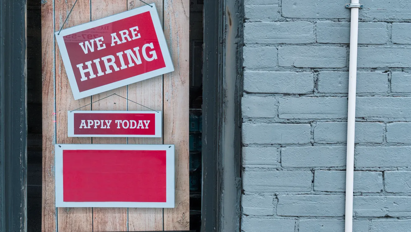 Now Hiring Sign on a shop door