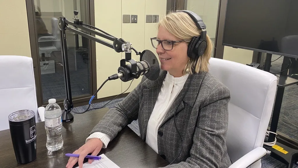 Kimberly Hauck in a soundbooth speaking into a microphone