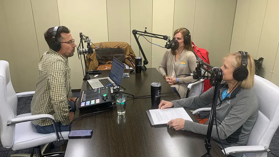 Scott Light at a podcasting table speakign with Lisa Armitage and Peggy Mills