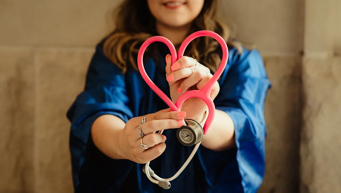A nurse folding a stethoscope into a heart