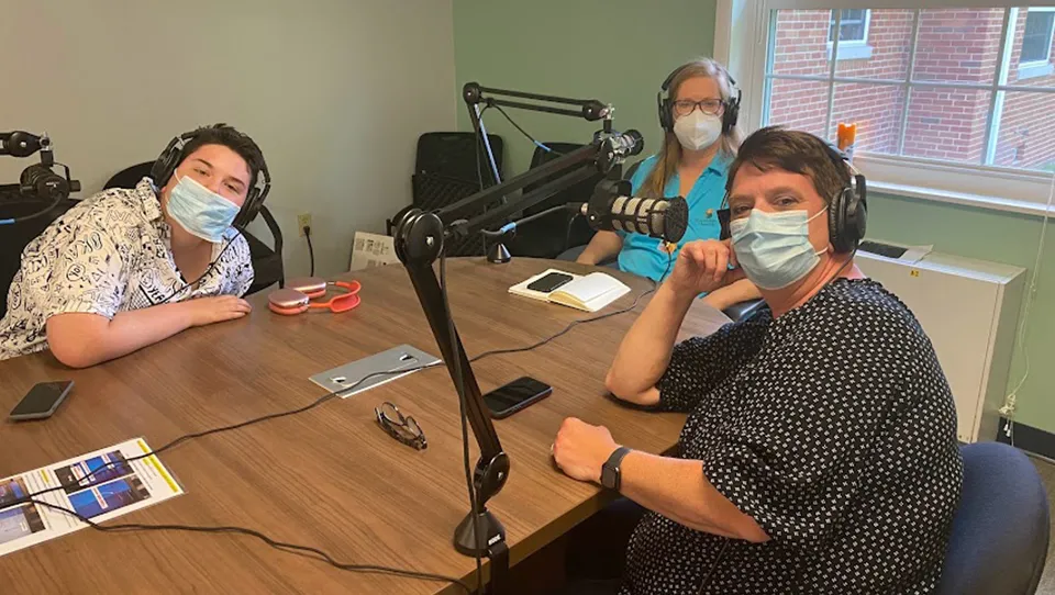 Dr. Ripsin, Mac Smith, and Jessica Smith at a table recording a podcast.