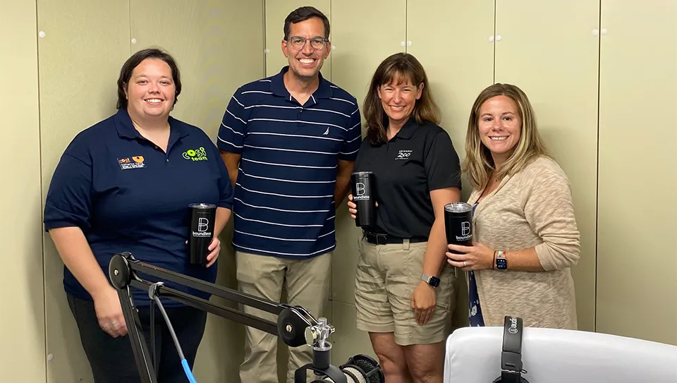three podcast guests and host scott light in a recording booth. 