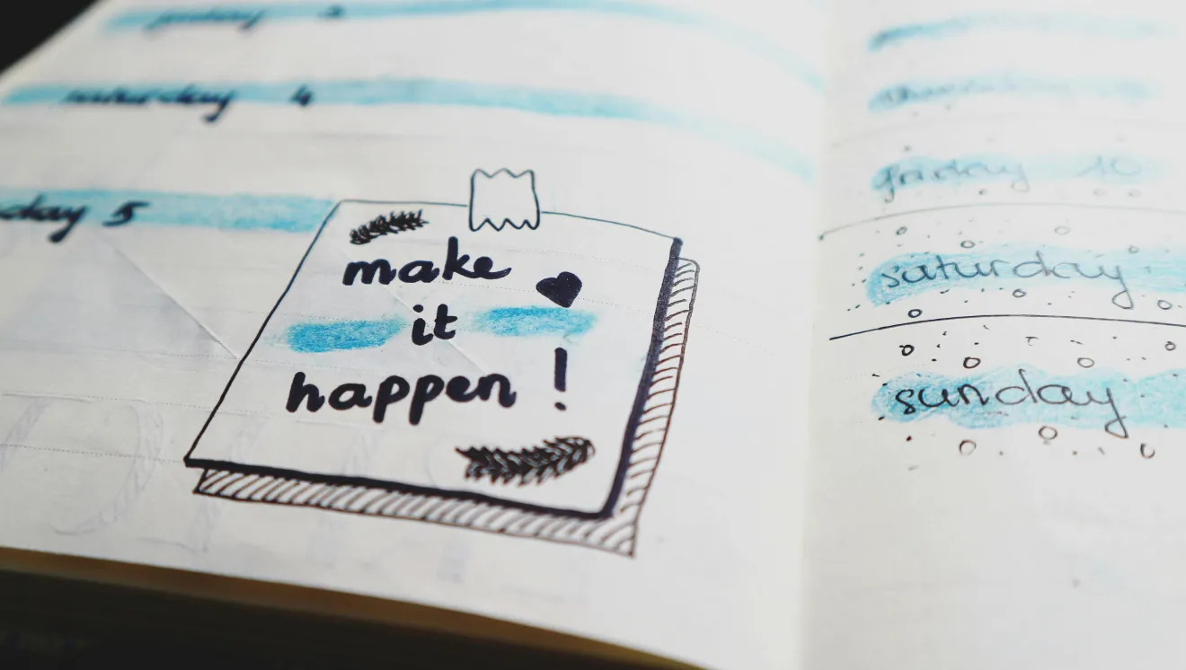 A planner with handwritten text that says "Make it Happen"