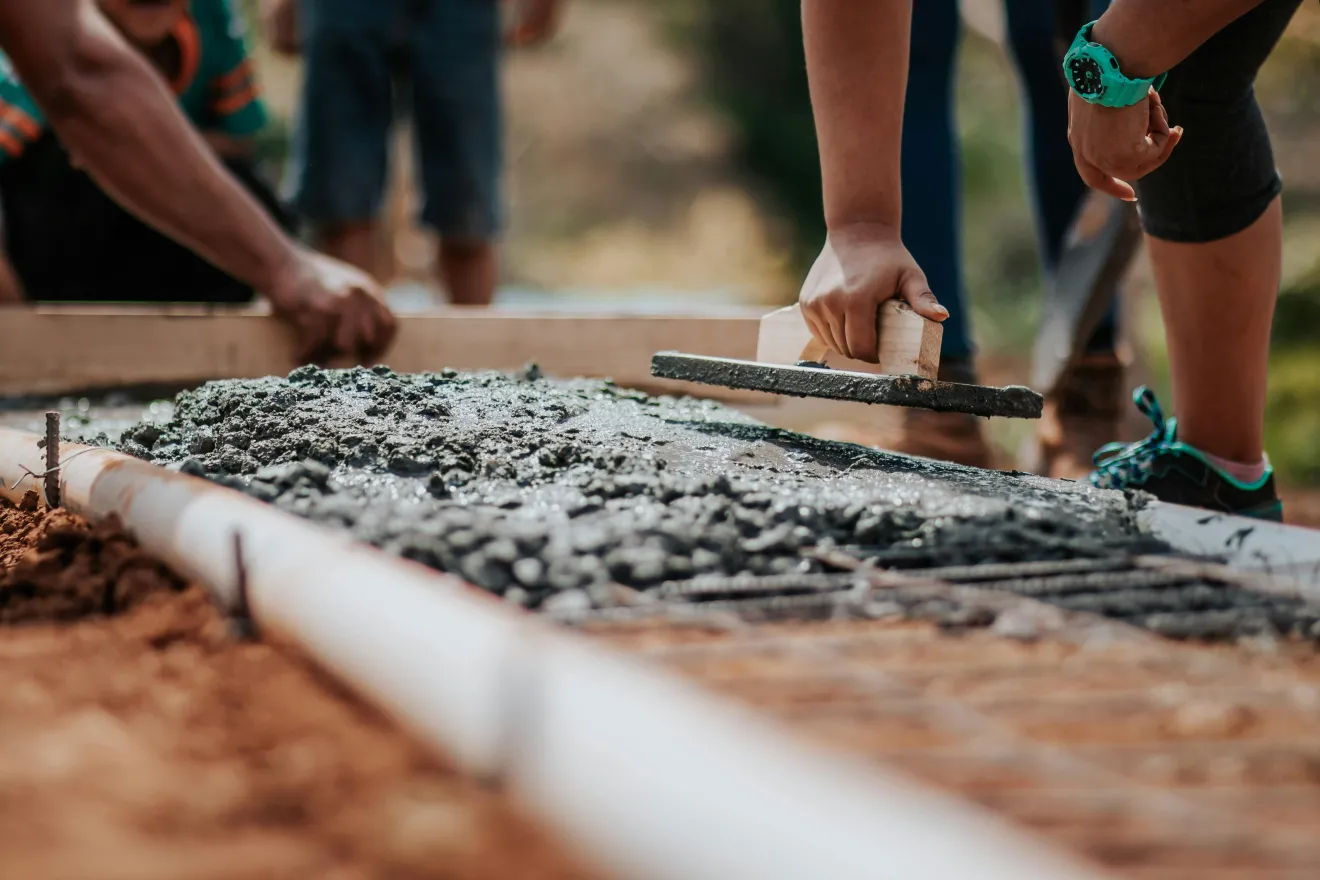people laying a foundation of a house