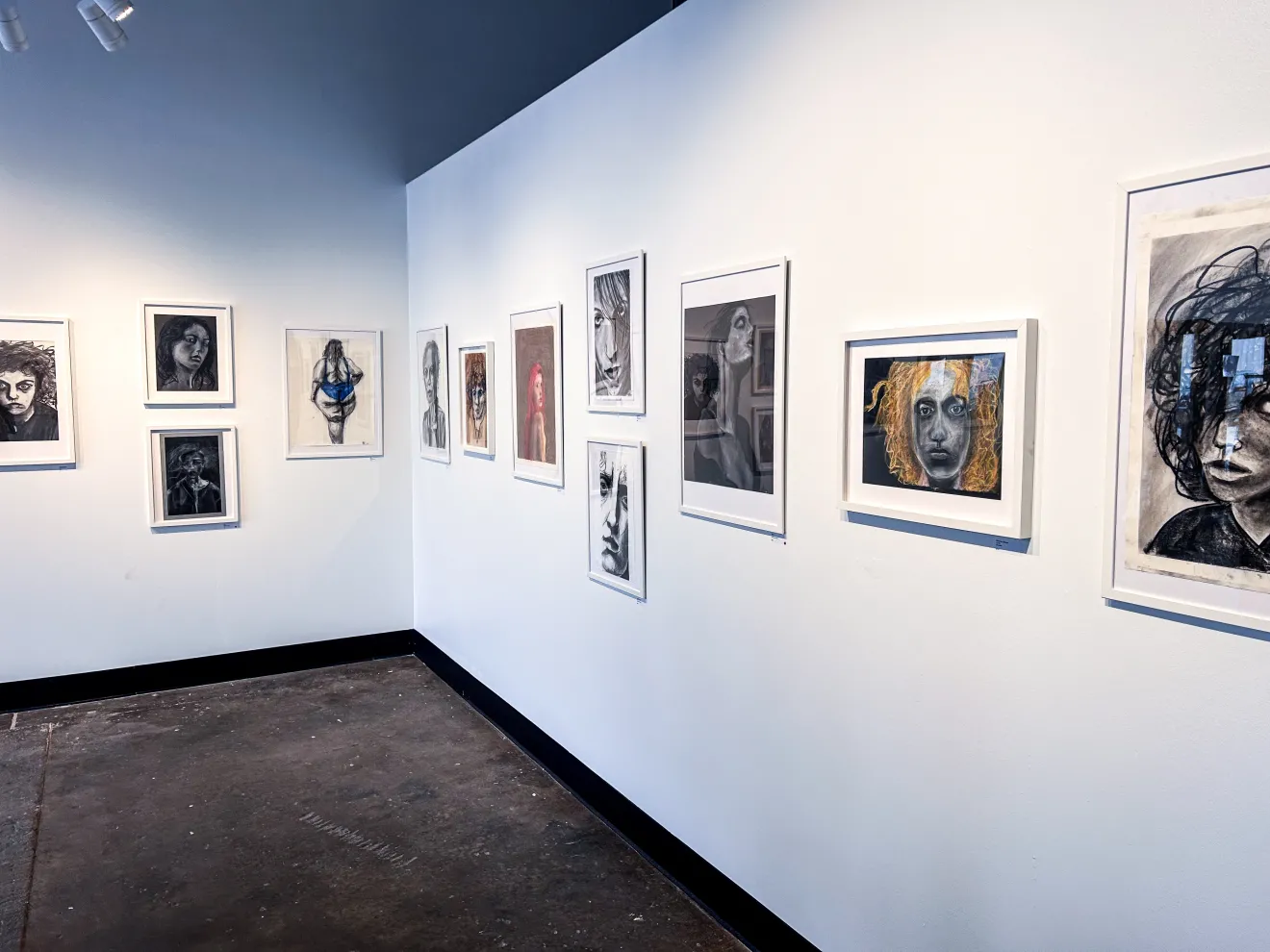 Two walls of Bothager's exhibit, lined with framed art