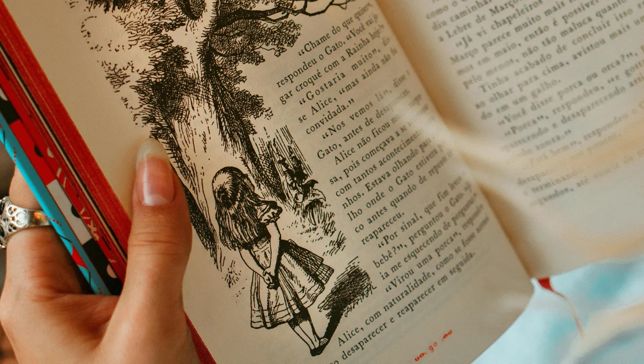 Hands holding and open book with text and black and white fairytale illustrations