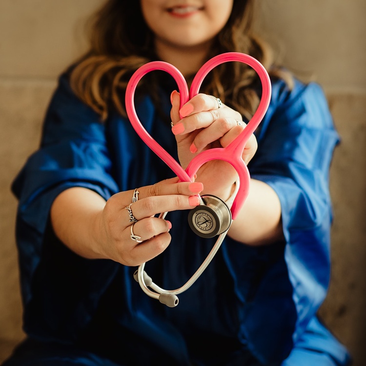 A nurse folding a stethoscope into a heart